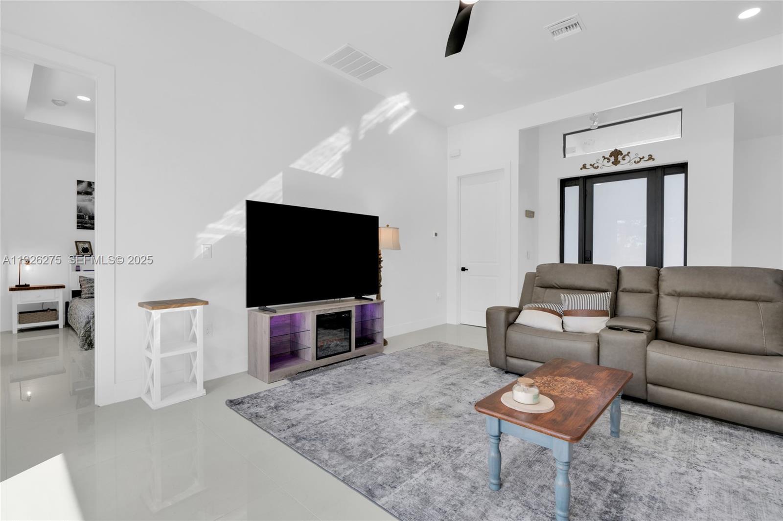 2250 10th Terrace Lehigh Acres, FL 33936 - Photo 18 of 39 a living room with furniture and a flat screen tv