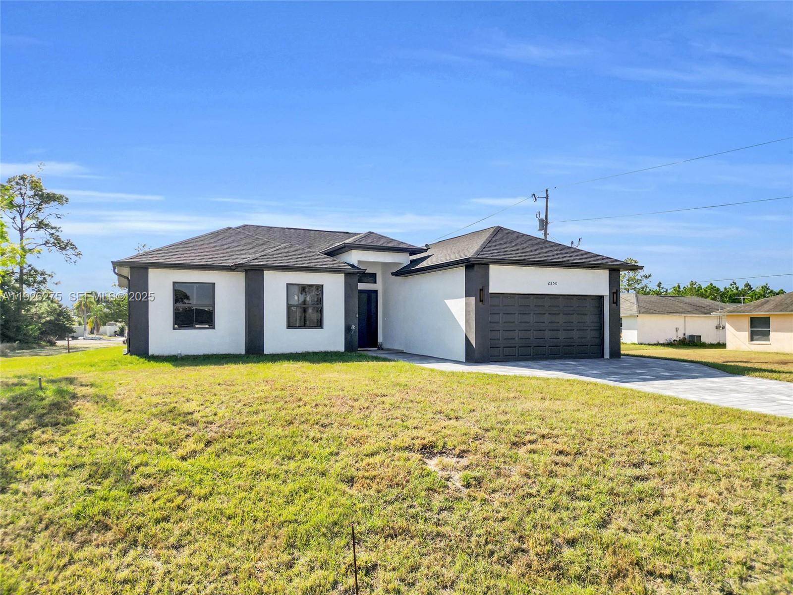 2250 10th Terrace Lehigh Acres, FL 33936 - Photo 2 of 39 a house view with a garden space