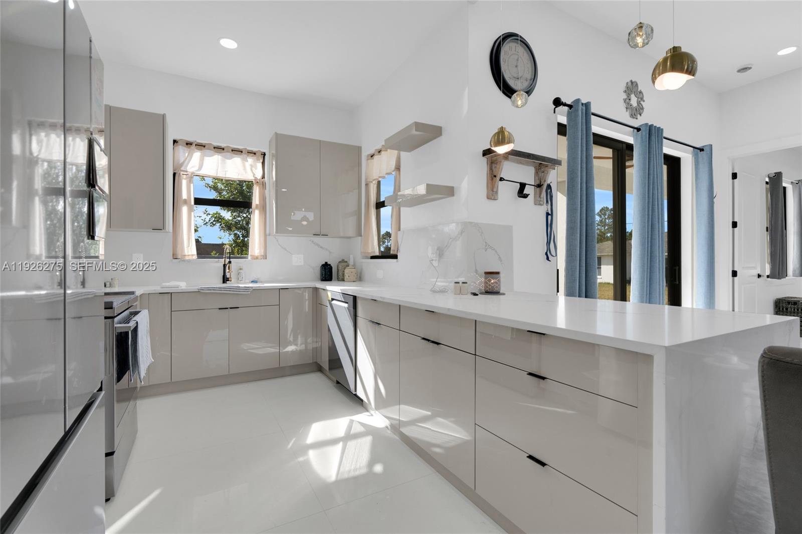 2250 10th Terrace Lehigh Acres, FL 33936 - Photo 24 of 39 a large white kitchen with a sink and cabinets