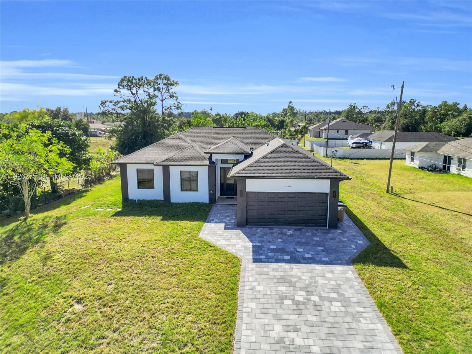 2250 10th Terrace Lehigh Acres, FL 33936 - Photo 5 of 39 a house view with a swimming pool garden and outdoor seating
