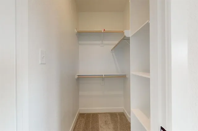 a view of walk in closet with empty racks