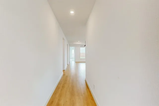 a view of a hallway with wooden floor