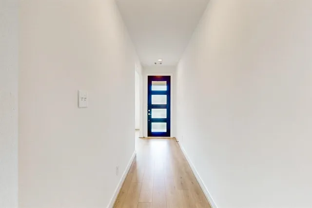 a view of a hallway with wooden floor and entryway
