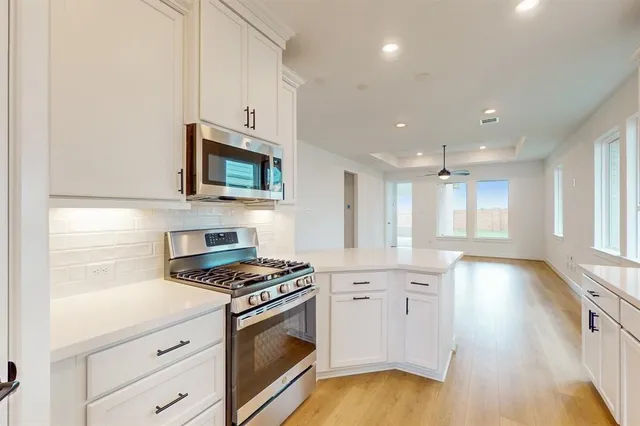 a kitchen with granite countertop a stove a sink and a microwave
