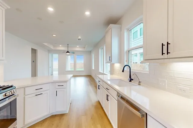 a large kitchen with cabinets and wooden floor