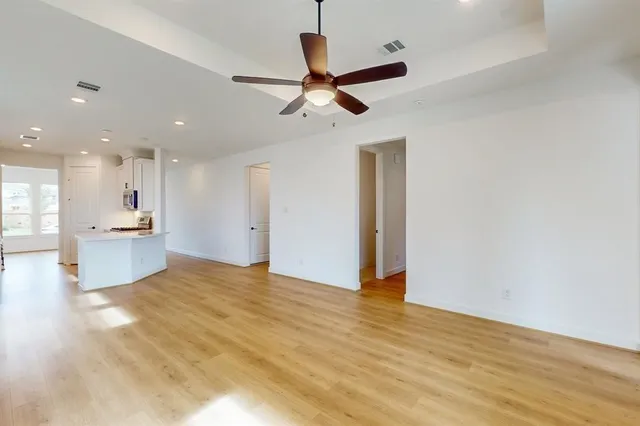 a view of empty room with wooden floor and ceiling fan