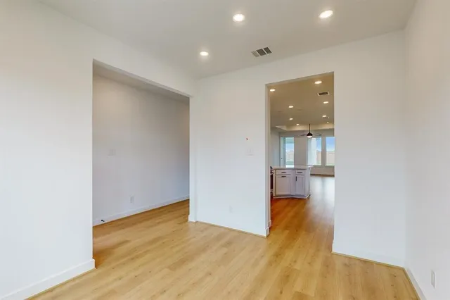 a view of empty room with wooden floor and cabinet