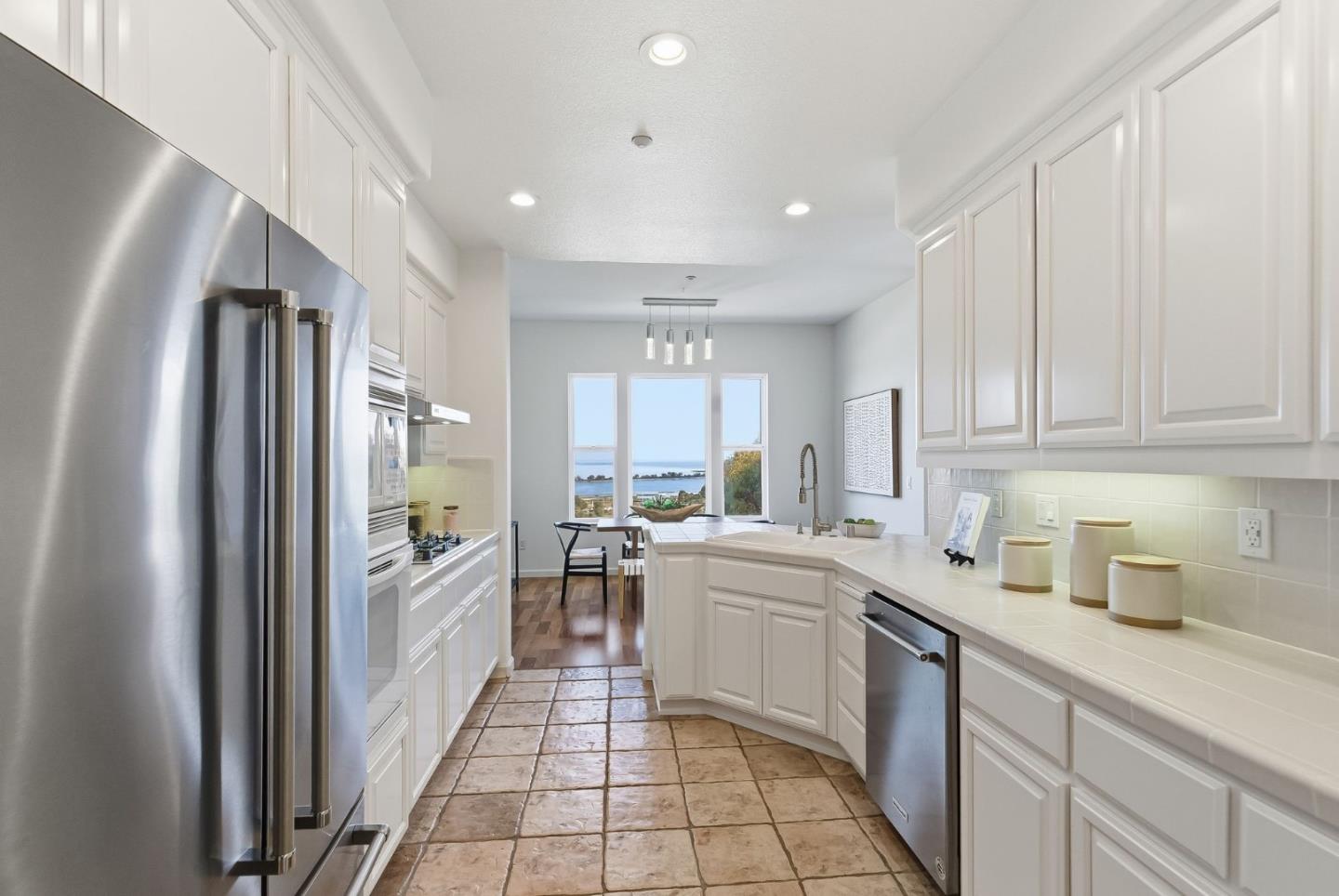 121 Cliff Swallow Court Brisbane, CA 94005 - Photo 16 of 50 a kitchen with white cabinets and appliances