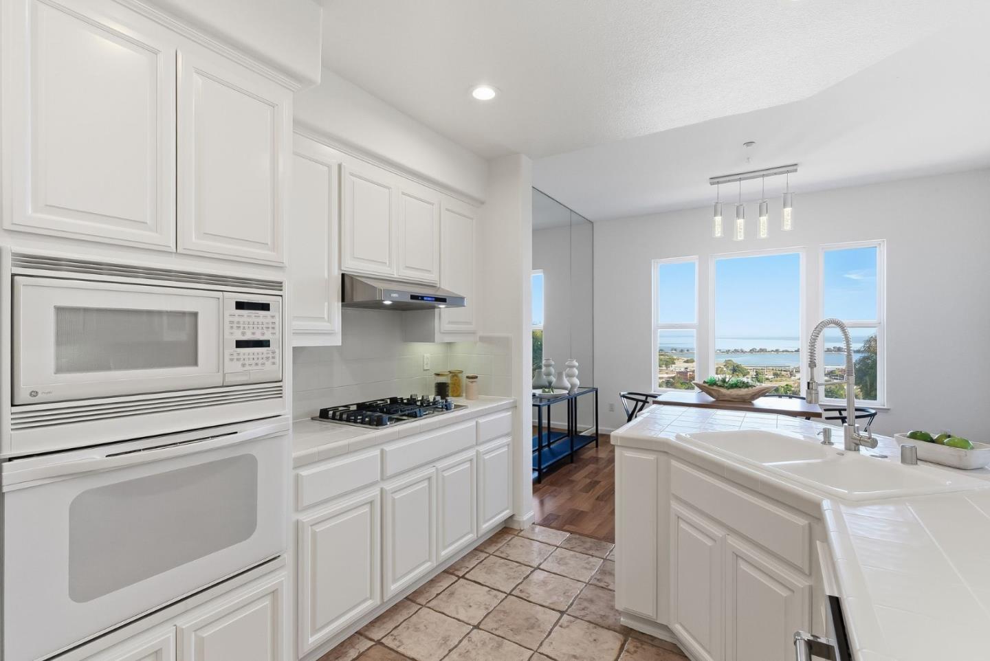 121 Cliff Swallow Court Brisbane, CA 94005 - Photo 17 of 50 a kitchen with granite countertop a sink a stove a washer and dryer