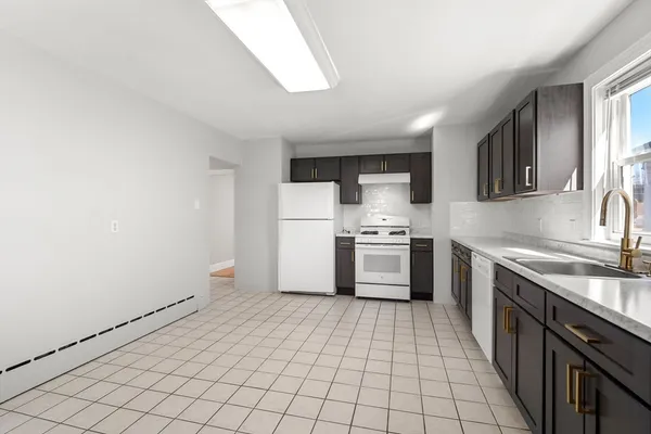 a kitchen with a sink a stove top oven and cabinets