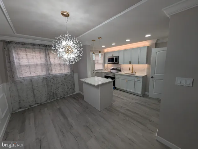 a kitchen with kitchen island a sink stainless steel appliances and cabinets