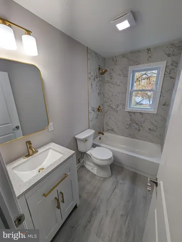 a bathroom with a sink mirror vanity and toilet