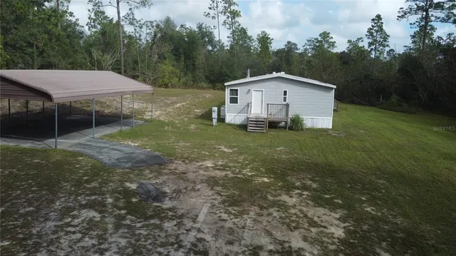 a backyard of a house with table and chairs