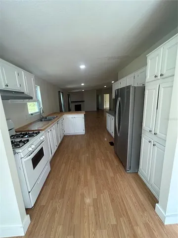 a kitchen with refrigerator and white stove