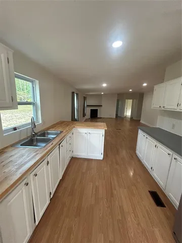 a large kitchen with stainless steel appliances granite countertop a lot of counter space and wooden floors