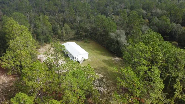 a backyard of a house with lots of green space and trees
