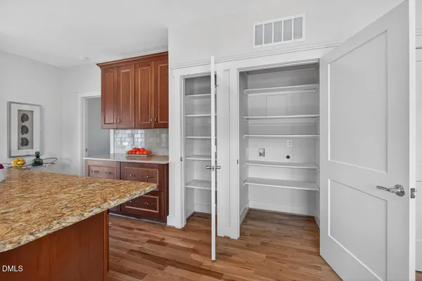 a metallic refrigerator sitting in a kitchen next to a window