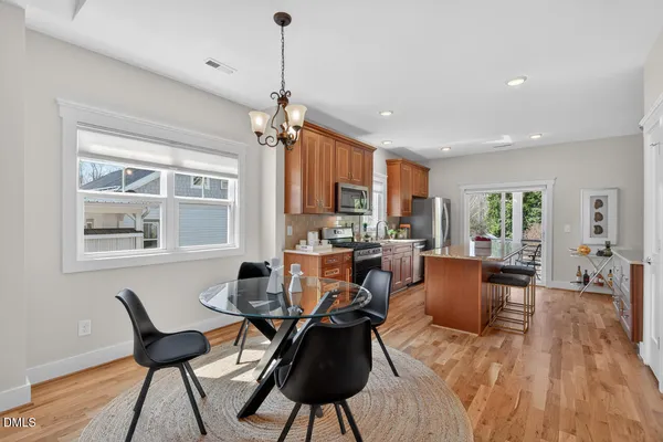 a kitchen with stainless steel appliances granite countertop wooden floors a stove top oven a granite counter space and a window