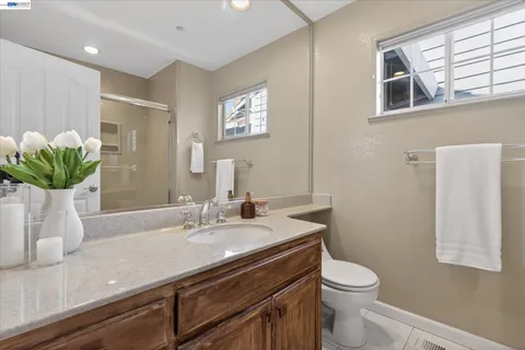 a bathroom with a granite countertop sink a toilet and mirror