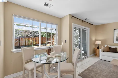 a dining room with furniture and large windows