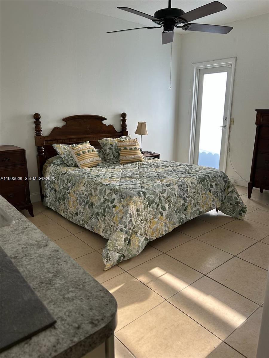 9525 Southwest 16th Street, Unit A Miami, FL 33165 - Photo 2 of 7 a bedroom with a bed and a chandelier