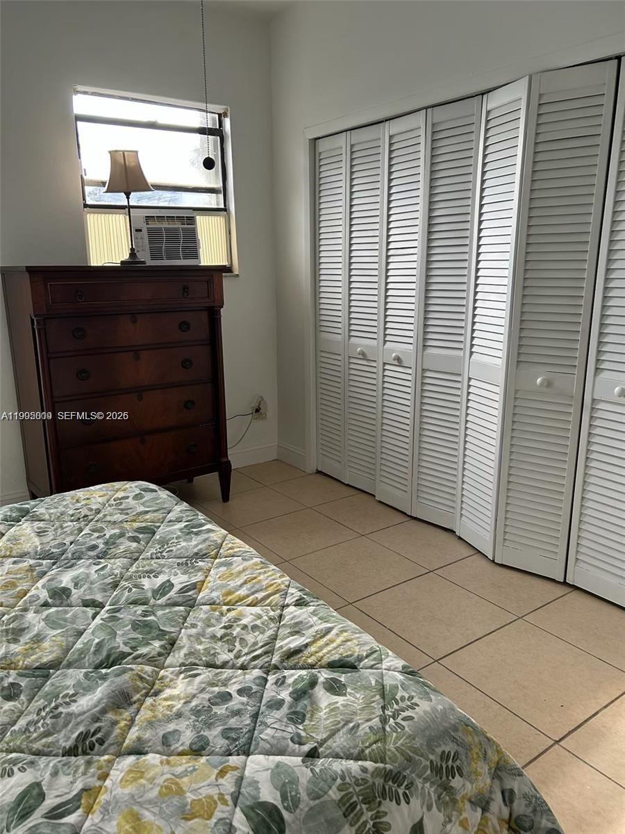 9525 Southwest 16th Street, Unit A Miami, FL 33165 - Photo 3 of 7 a bedroom with a bed and a mirror