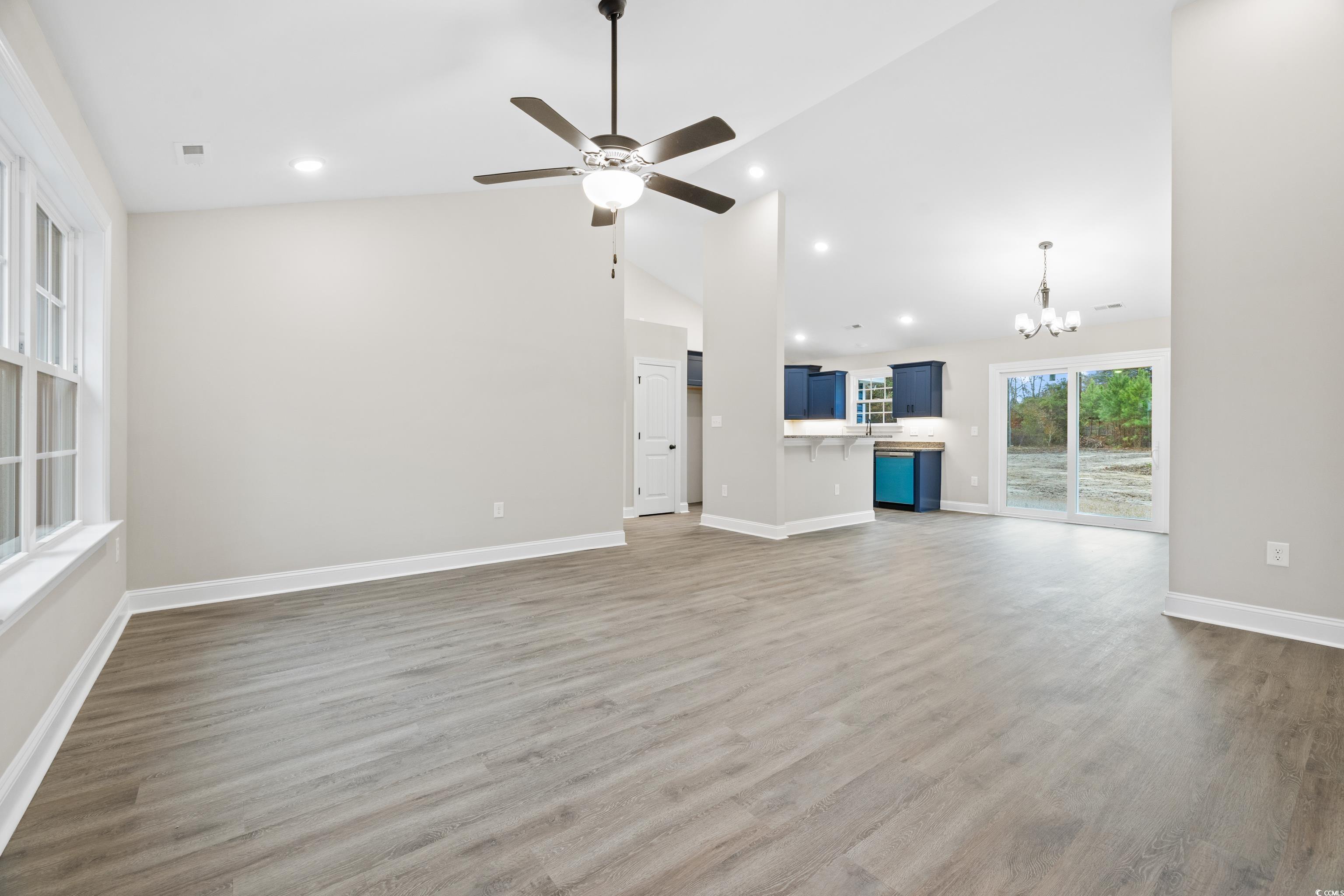 3646 Bethel Chapel Road Loris, SC 29569 - Photo 11 of 40 Unfurnished living room featuring a chandelier, dark wood-style flooring, recessed lighting, ceiling fan, and high vaulted ceiling