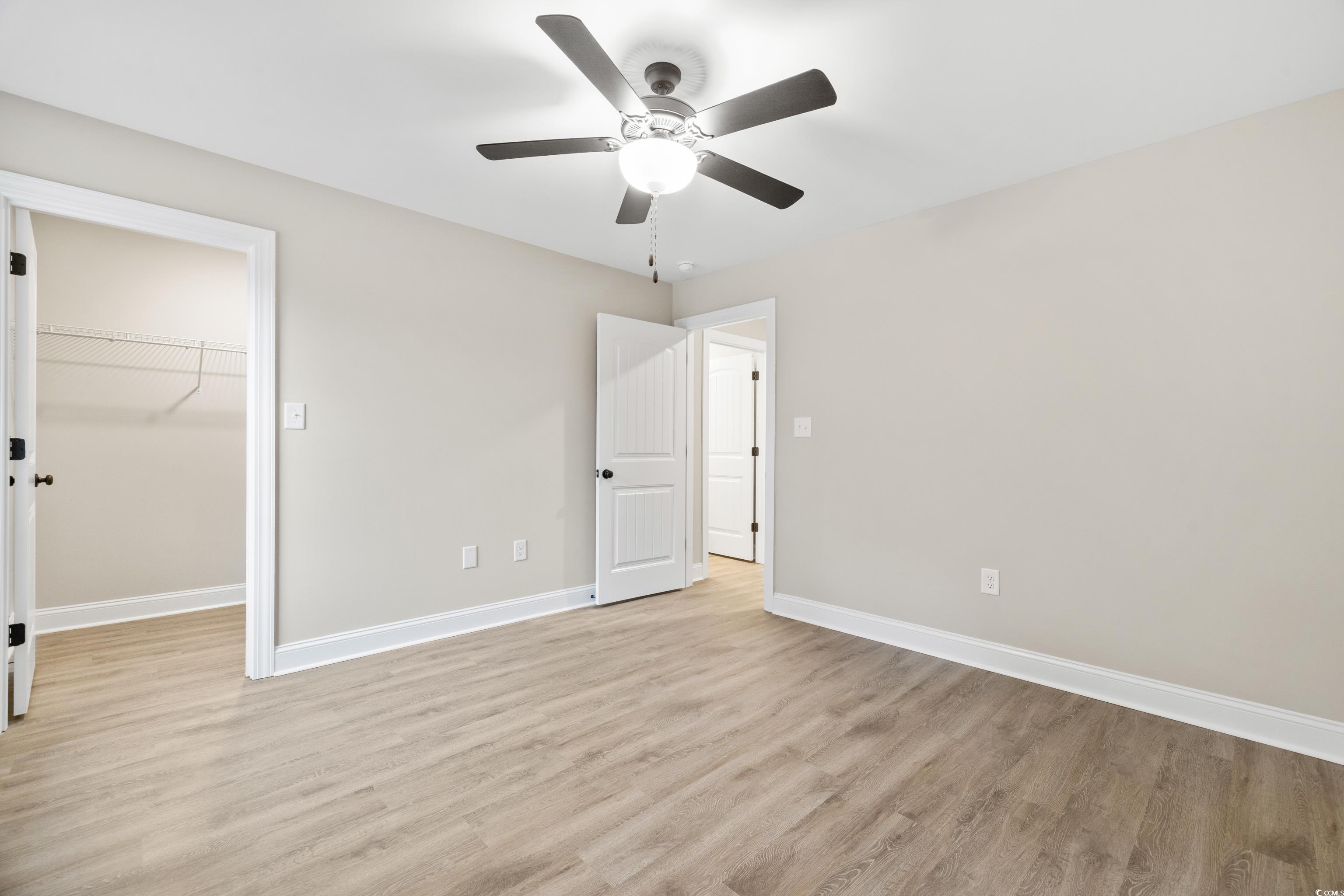3646 Bethel Chapel Road Loris, SC 29569 - Photo 36 of 40 Unfurnished bedroom featuring a walk in closet, light wood-style flooring, and ceiling fan
