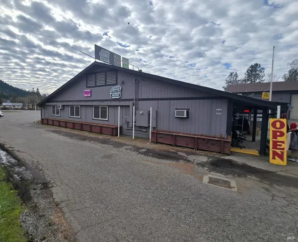 a view of a house with a patio and a yard