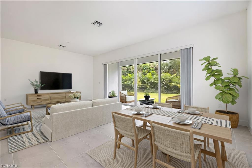Spacious living area featuring light-colored tile flooring and large sliding glass doors providing access to the outside area