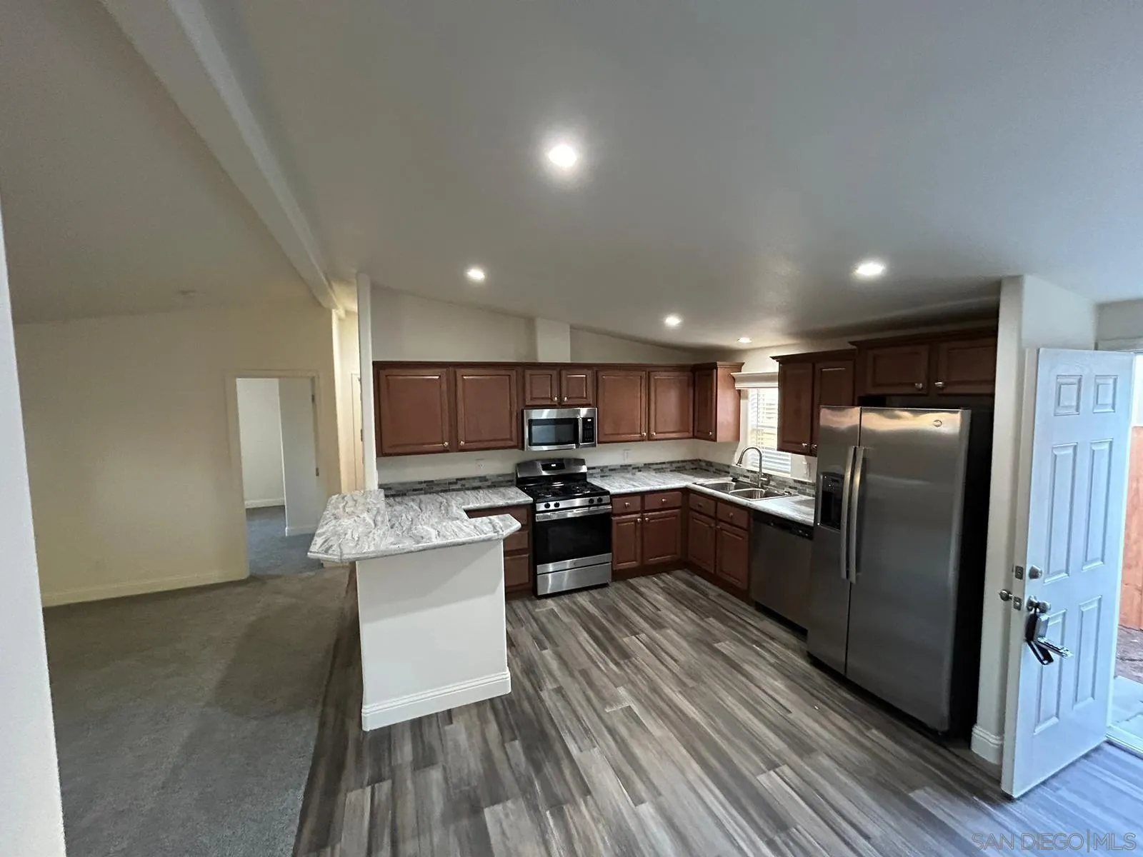 8975 Lamar Street Spring Valley, CA 91977 - Photo 35 of 59 a kitchen with stainless steel appliances kitchen island granite countertop a sink counter space and stainless steel appliances