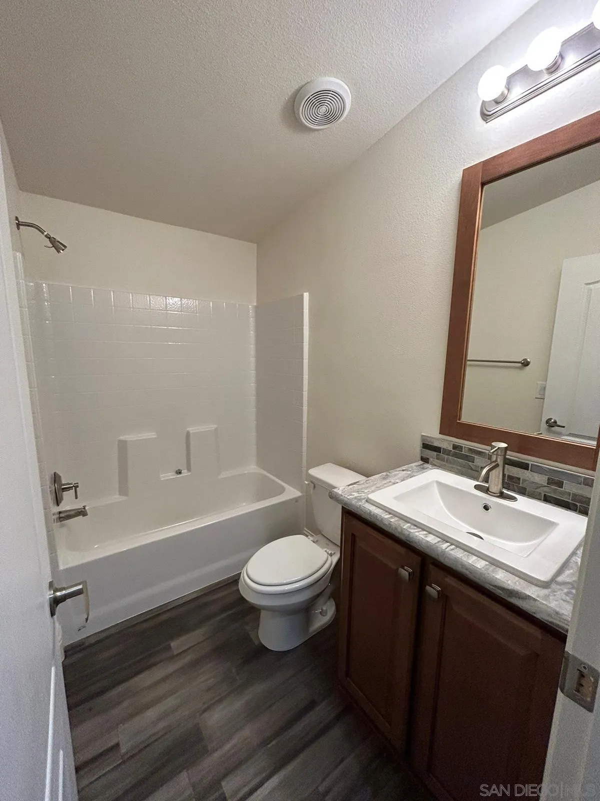 8975 Lamar Street Spring Valley, CA 91977 - Photo 39 of 59 a bathroom with a double vanity sink toilet mirror and bathtub