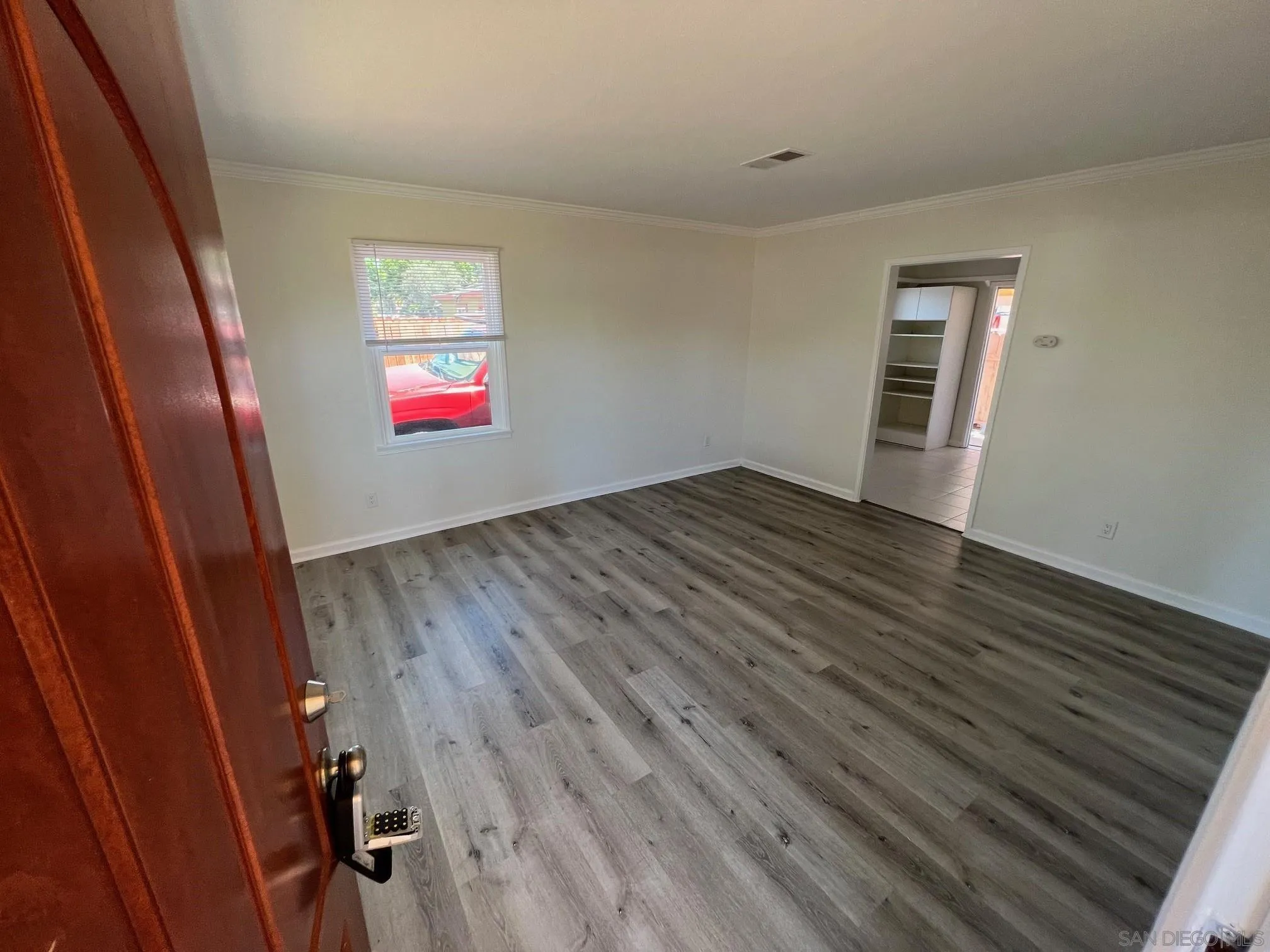 8975 Lamar Street Spring Valley, CA 91977 - Photo 56 of 59 a view of an empty room with wooden floor and a window