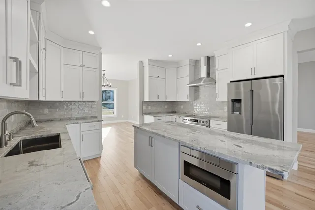 a kitchen with stainless steel appliances granite countertop a sink stove and refrigerator