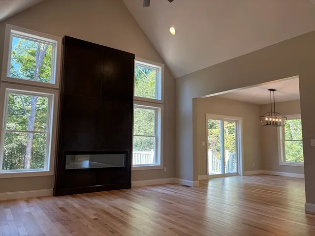 an empty room with wooden floor a ceiling fan and a window