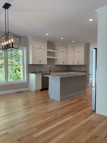 a large kitchen with stainless steel appliances granite countertop a stove and a sink
