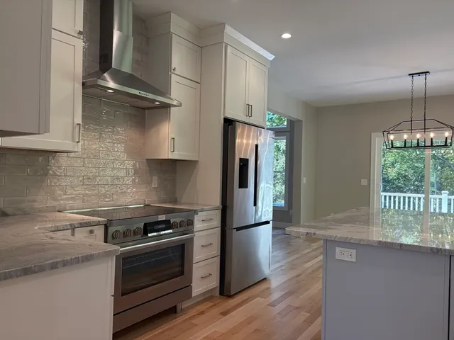 a kitchen with granite countertop a stove and a refrigerator