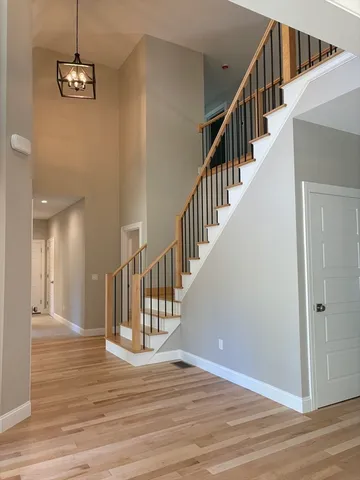 a view of a hallway with wooden floor and staircase