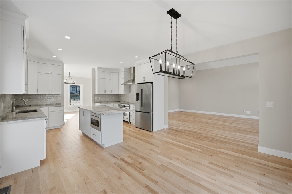 130 Linden Ridge Road Amherst, MA 01002 - Photo 10 of 40 a kitchen with stainless steel appliances granite countertop a refrigerator a sink dishwasher a stove and white cabinets with wooden floor