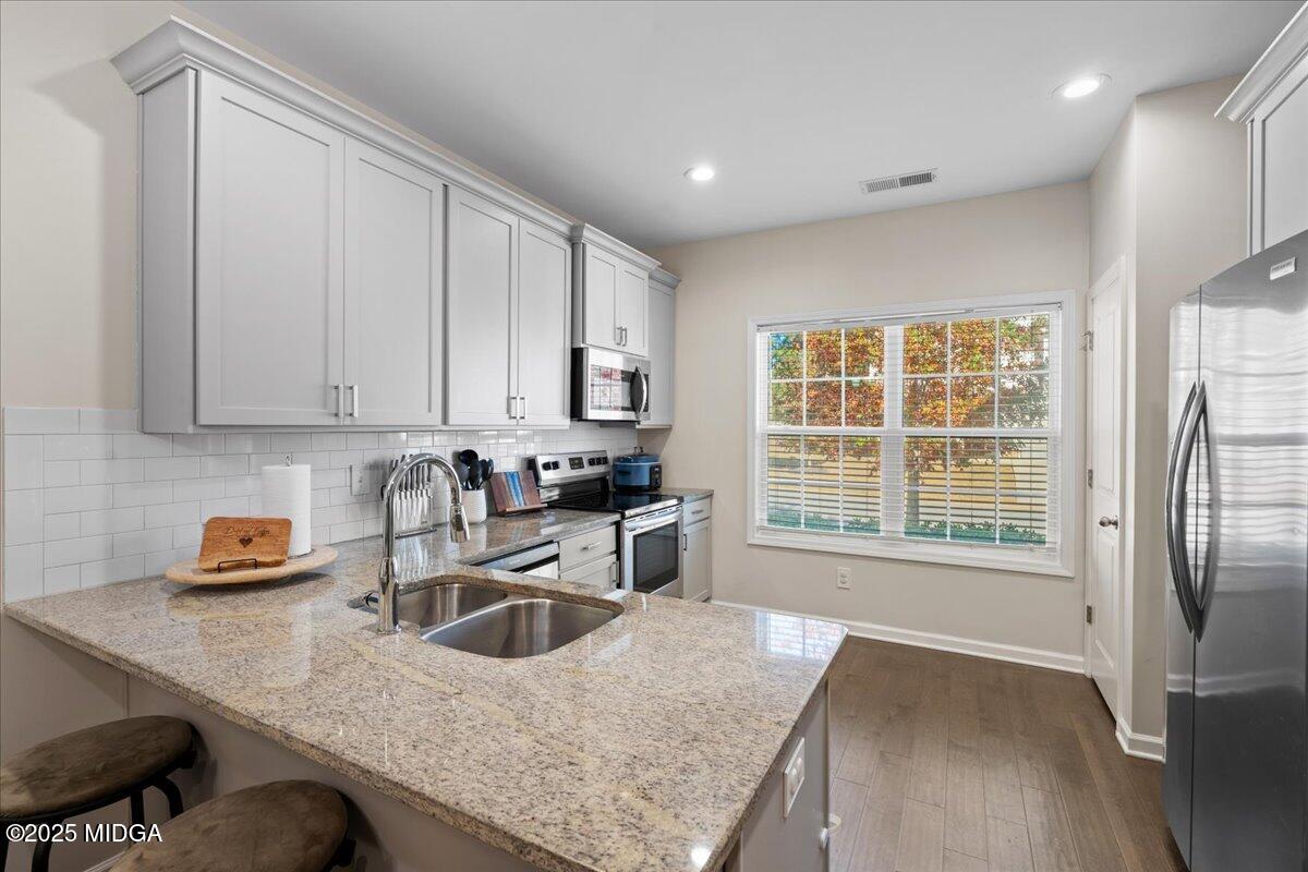 108 East E River Perry, GA 31069 - Photo 11 of 38 a kitchen with stainless steel appliances granite countertop a sink a stove and a refrigerator