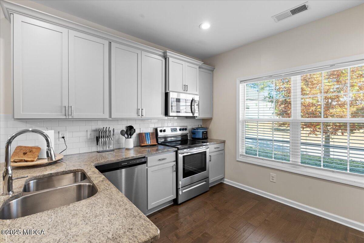 108 East E River Perry, GA 31069 - Photo 12 of 38 a kitchen with granite countertop a sink stove and cabinets