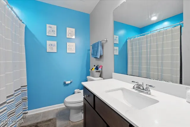 a bathroom with a sink a toilet and shower curtain