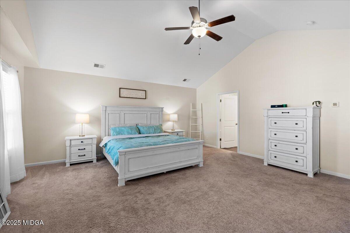 108 East E River Perry, GA 31069 - Photo 25 of 38 a spacious bedroom with a bed and a chandelier