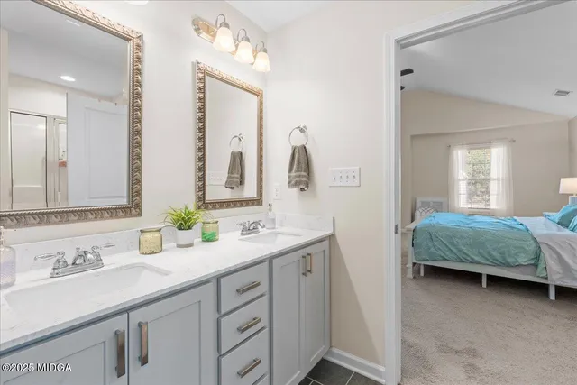 a en suite bathroom with a double vanity sink and a mirror