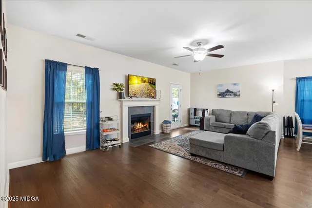 a living room with furniture a fireplace and a flat screen tv