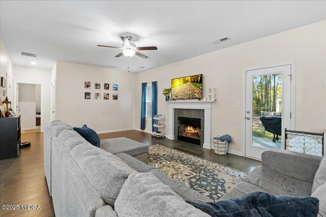 a living room with furniture a flat screen tv and a fireplace