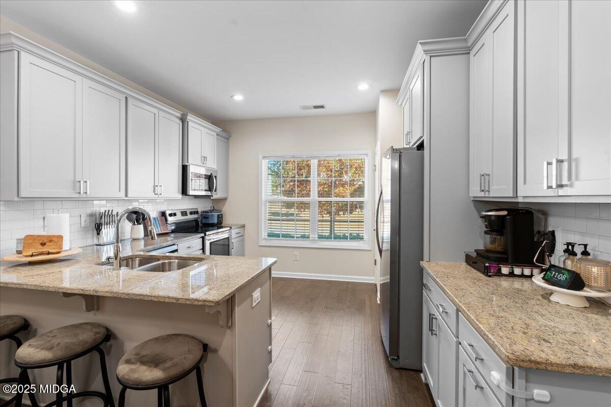 108 East E River Perry, GA 31069 - Photo 10 of 38 a kitchen with granite countertop a sink chairs and cabinets