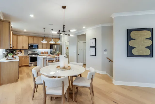 a kitchen with a dining table chairs and view of living room