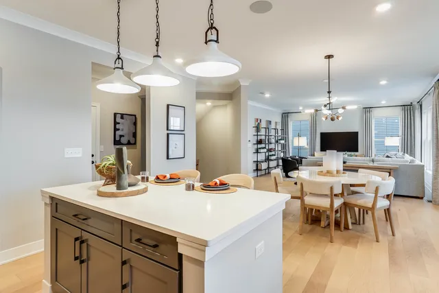 a large kitchen island with a dining table wooden floor and a chandelier