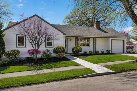 a front view of a house with a yard and potted plants